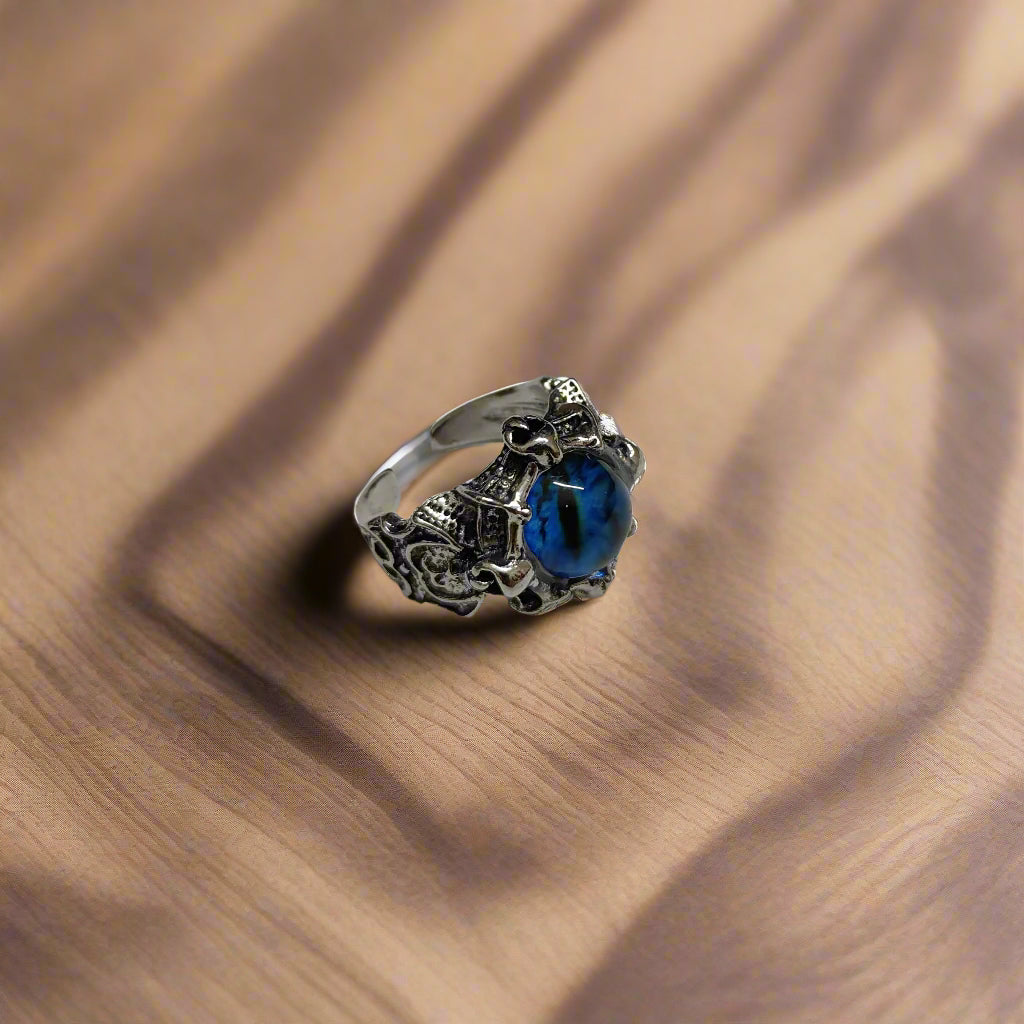 Silver ring with a blue gemstone on a textured gray background